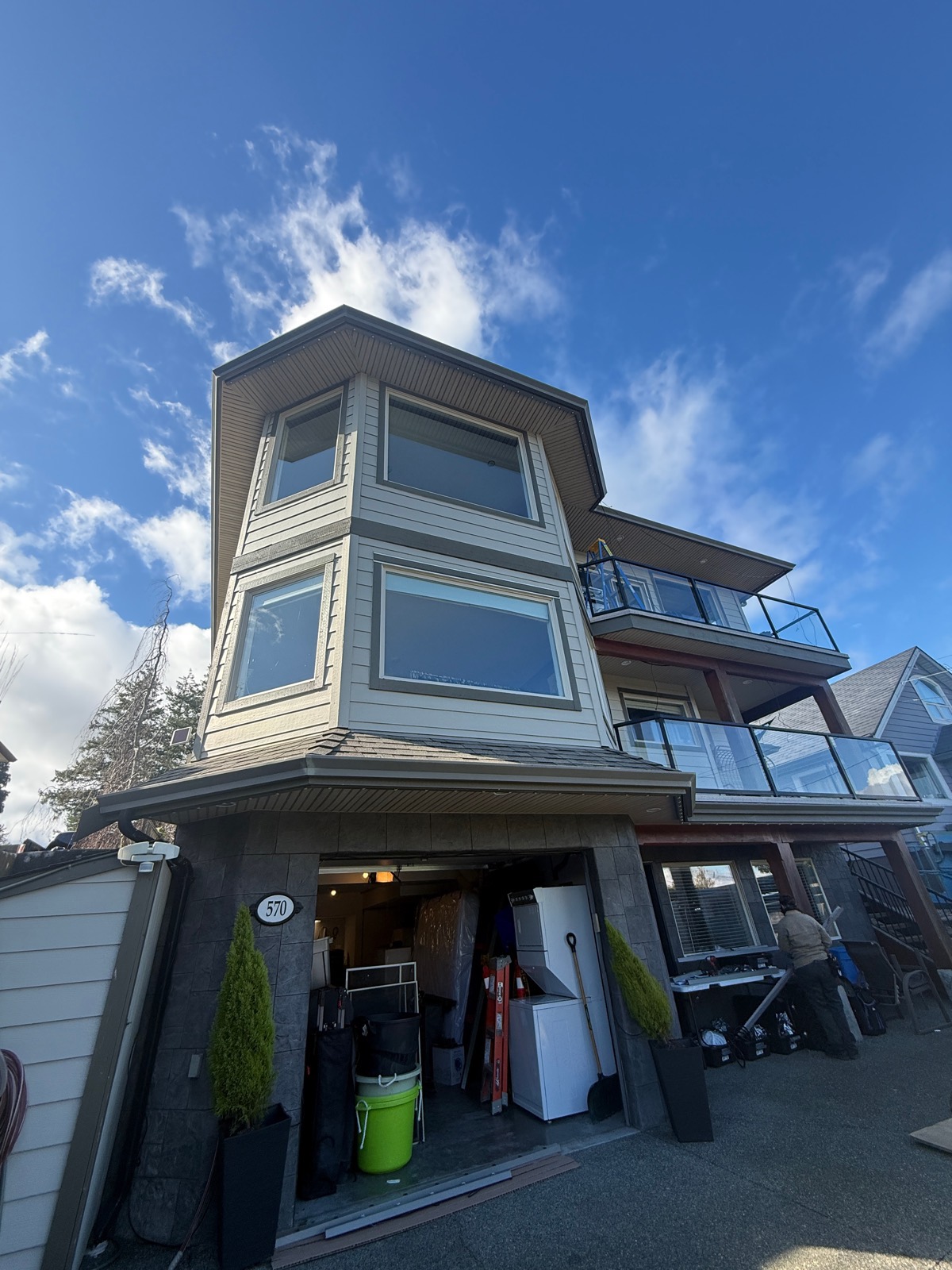 A Massey technician installing Gemstone Lights on a three-storey home.