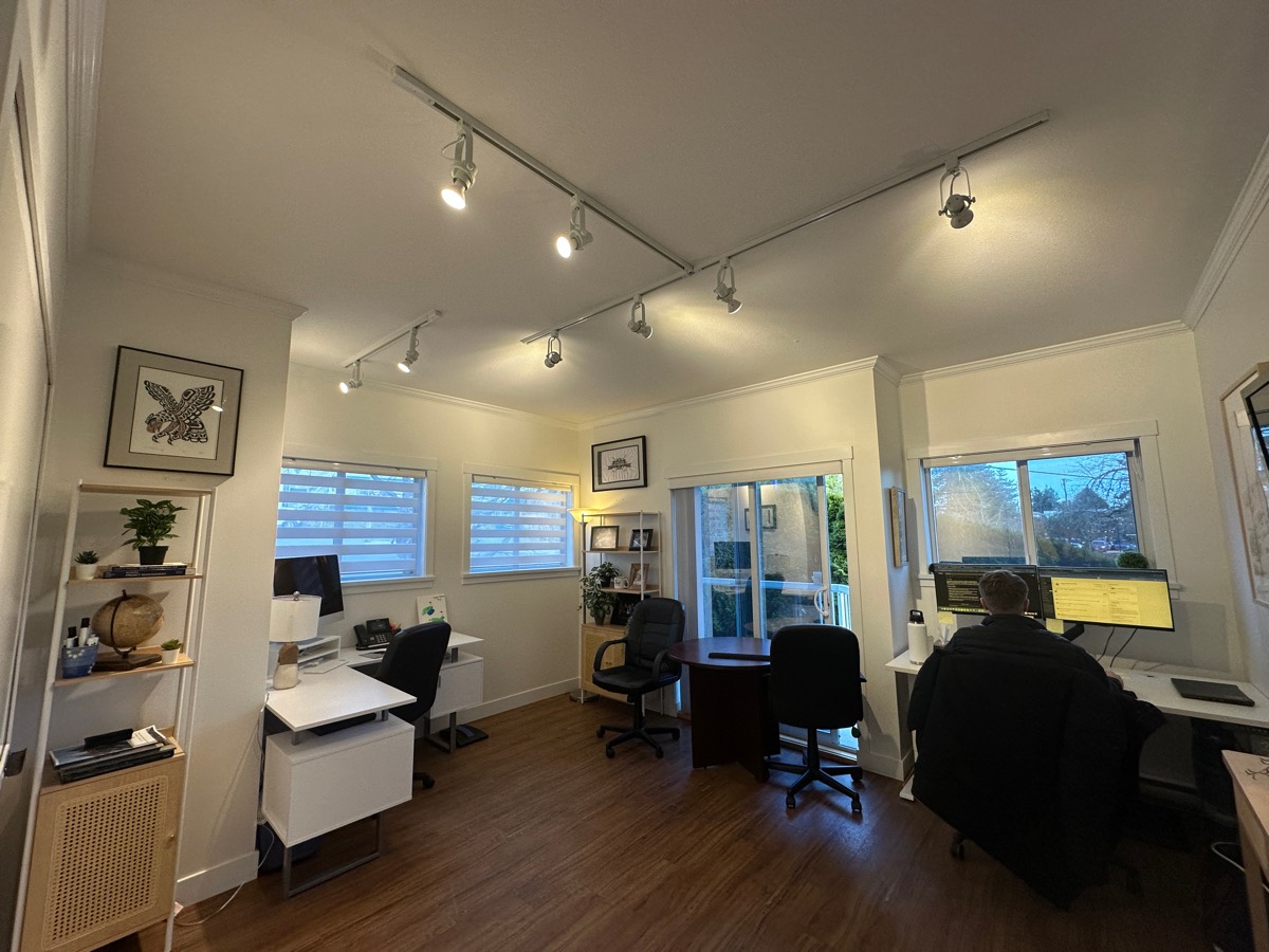 An office after a lighting upgrade, with track lighting and LED panels.