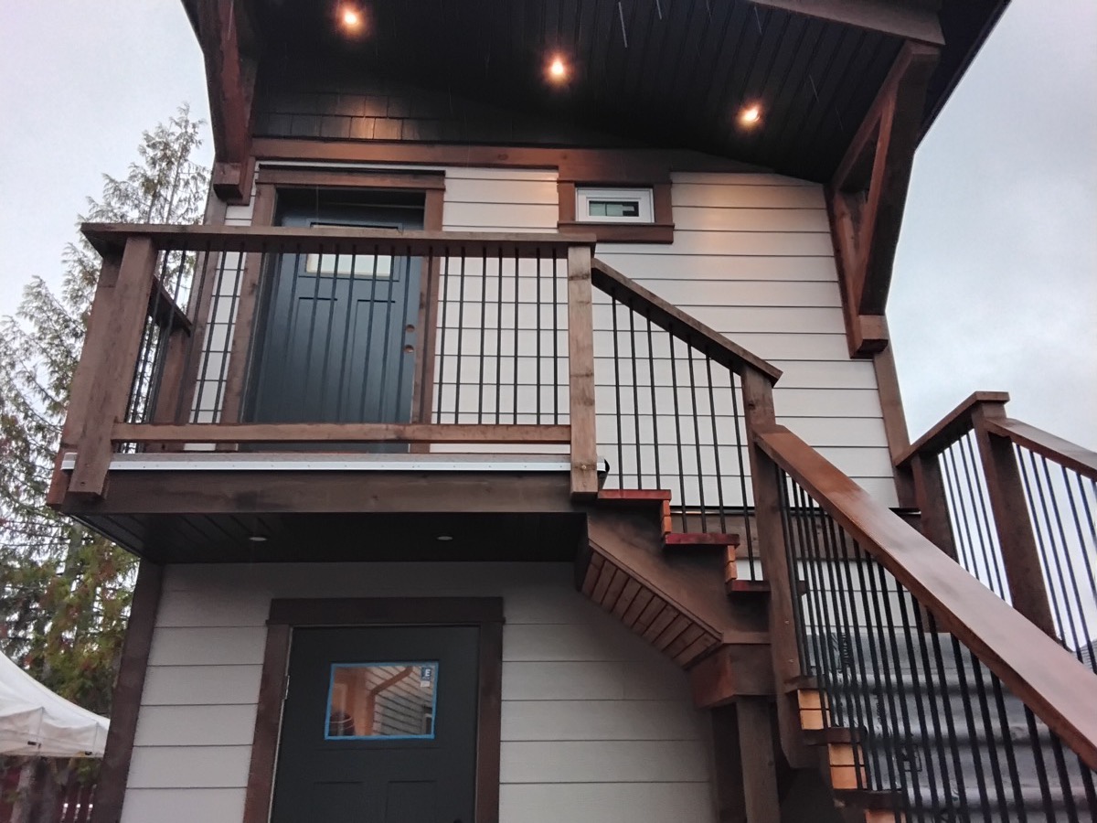 Soffit pot lights in the ceiling of a covered deck over an exterior stair.